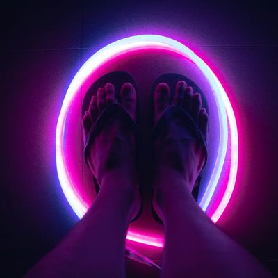 Abstract shot of feet in motion on a dark floor.